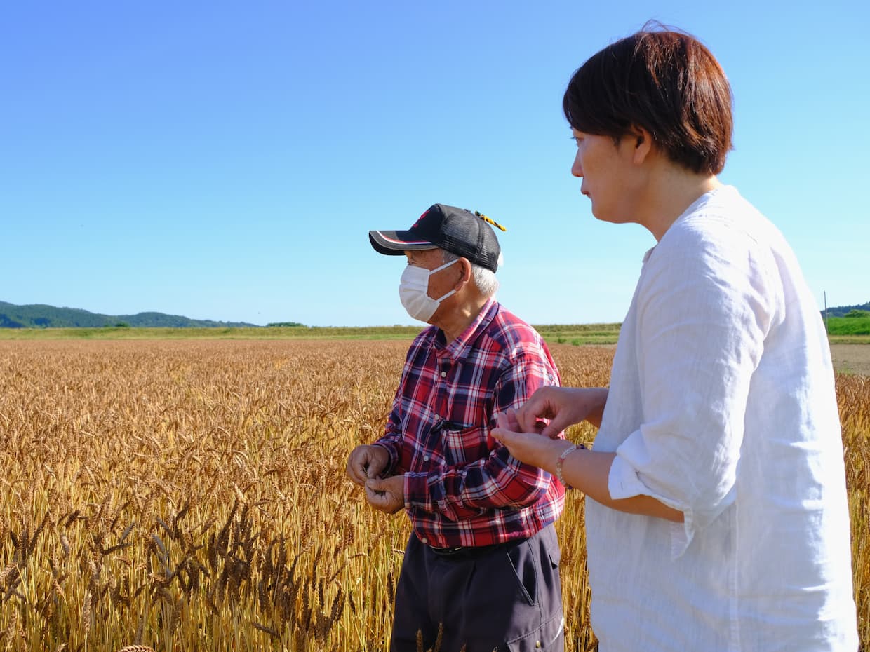 麦畑を見渡す夏黄金の名付け親、安部瑞雄さんと丹治奈緒子さん